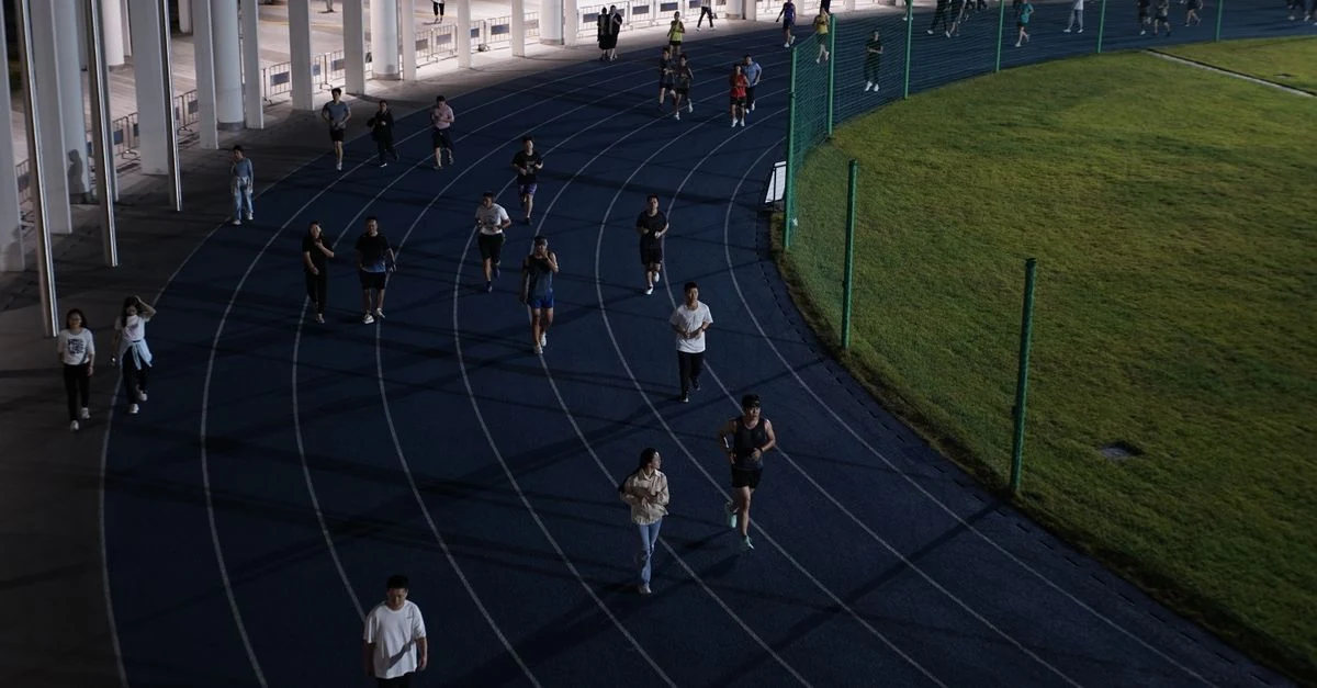 陸上トラックで5km20分切りに向けたペース走をする市民ランナー